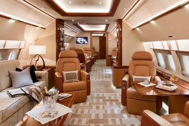 Luxury private jet interior featuring spacious seating, refined wood finishes, and VIP amenities. Designed for executive trav
