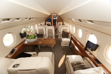 Spacious luxury private jet cabin featuring plush leather seating, elegant wood finishes, and VIP amenities. Designed for eli