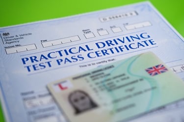 UK practical driving test pass certificate from the DVSA alongside a provisional driving license.