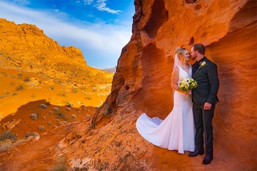 A bride and groom posing for wedding photos amidst the red sandstone formations at Valley of Fire State Park.