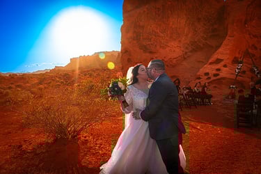 a bride and groom kissing in the desert