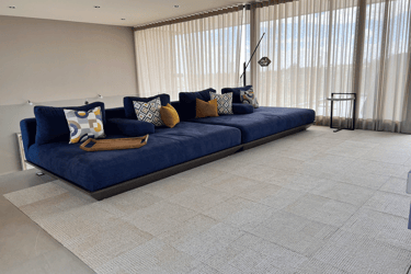 Sala minimalista con sofá azul y cojines decorativos, interiorismo | KARÄNA