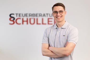 Felix Paulus Steuerfachangestellter, im Hintergrund Schriftzug Steuerberatung Schüller