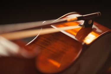 Cello laid on its side with a bow laying across the ribs