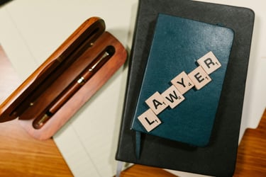 una caja de madera con un bolígrafo y unas letras de juego diciendo lawyer