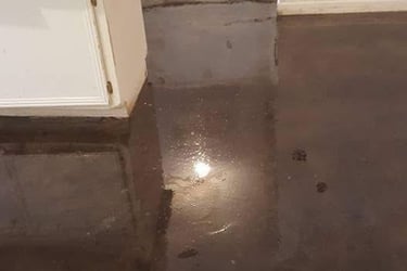 a kitchen floor with a wet floor and a sink