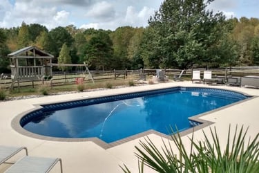 a pool with a lounge chair and a lounge chair