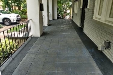 a long narrow walkway with a car parked on the side of the road