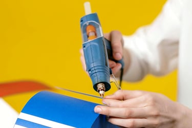 Craft person using a glue sticks in a hot melt glue gun