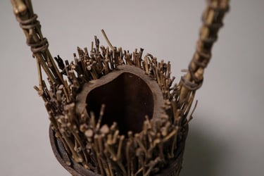 Handcrafted rustic flower vase made from bundled natural twigs and bamboo for organic home decor.