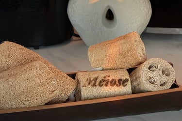 Handcrafted decorative wooden vessels in various wood grains arranged in a diagonal line with dramatic sunlight shadows.