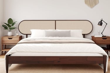 Mid-century modern dark wood bed frame with a woven cane headboard in a bright minimalist bedroom.