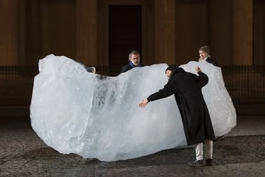 Olafur Eliasson "ice watch" a man and woman standing in front of a large iceberg