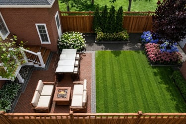 Aerial view of a modern backyard landscape with a brick patio, outdoor dining set, fire pit, and lush green lawn.