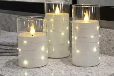Three gray pillar candles with flickering LED flames and internal star string lights are displayed