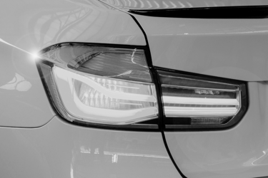 Close-up of a modern luxury car LED taillight in black and white highlighting sleek automotive design.