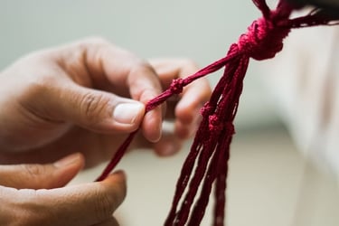 Estudiante aprendiendo nudos básicos para una pieza artesanal de macramé.