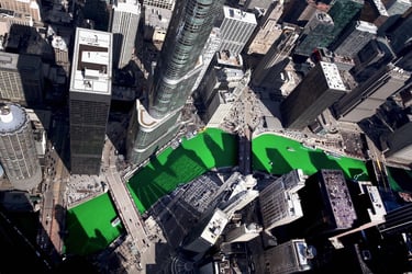 Aerial view of the bright green Chicago River during St. Patrick's Day celebrations surrounded by city skyscrapers.