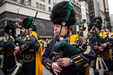 NYPD pipe and drum band members playing bagpipes during a St. Patrick's Day parade in New York City.