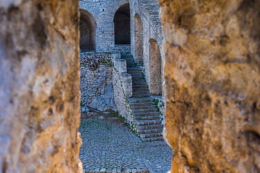 Ancient Palamidi Fortress stone stairs and arches in Nafplio Greece viewed through a window.