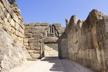 The ancient Lion Gate of Mycenae featuring a stone relief sculpture and Cyclopean masonry walls in Greece.