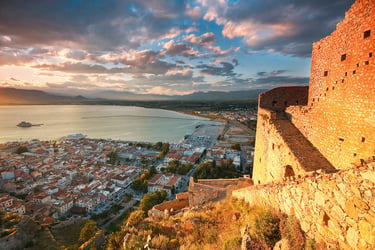 Golden sunset over the historic Palamidi Fortress overlooking the city of Nafplio and the Argolic Gulf in Greece.