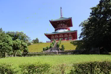 The Great Pagoda of Peace at Narita-san Shinsho-ji Temple in Japan atop a grassy hill.