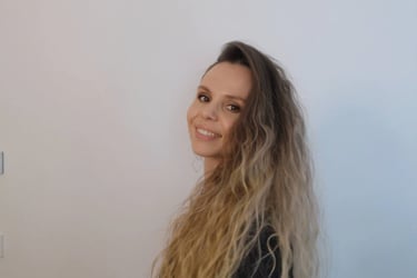 Christine Hauser, certified RTT Practitioner, smiling in a relaxed portrait against light background