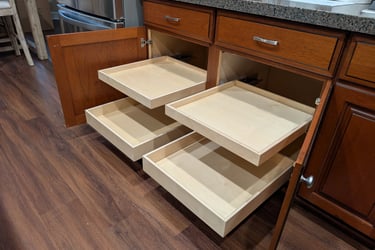 Four kitchen cabinet glide-out drawers extended from a large cabinet.