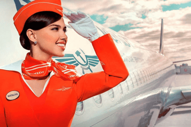 Hotesse de l'air méga confiante en tenue rouge devant l'avion