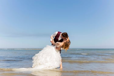Couple fraîchement marié s'embrasse à la plage