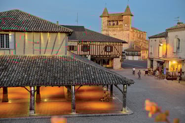 a town square with a clock tower and a clock tower Villeréal market