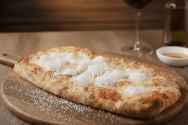 Pinsa romana με τυριά σε ξύλινη βάση