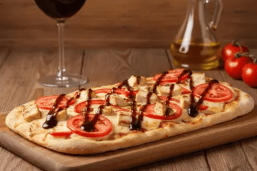 Pinsa romana με κοτόπουλο και σάλτσα ζικ ζακ  σε ξύλινη βάση