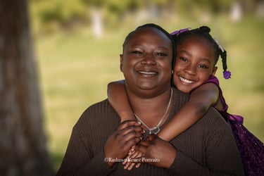 a woman holding a child in her arms posing for a family Portrait