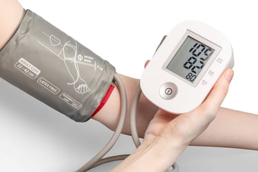 Digital blood pressure monitor showing health readings with an adult arm cuff on a patient.
