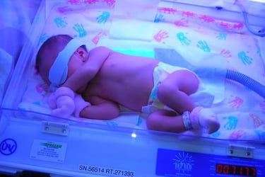 Newborn baby receiving phototherapy treatment for jaundice in a hospital neonatal incubator.