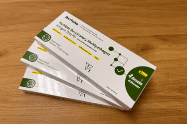 BioTeke multiple respiratory multipathogen antigen test kits for COVID-19, Influenza, and RSV on a desk.