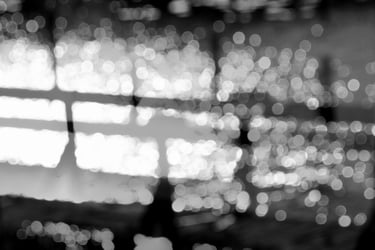 a bench on a jetty by the water and bokeh