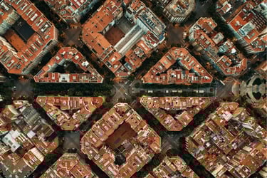High-angle aerial view of Barcelona's Eixample district featuring unique octagonal city blocks and red rooftops.
