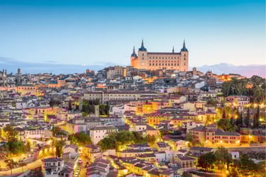 Panoramic sunset view of the historic Toledo skyline and Alcázar fortress in Spain.