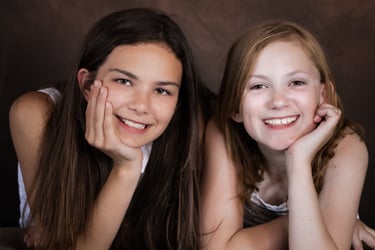 two girls are smiling and posing for a picture