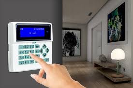 Person using a home security alarm keypad to arm or disarm the system in a modern hallway