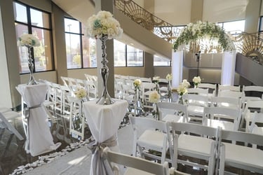 a wedding ceremony with white chairs and white chairs
