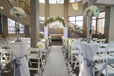 a wedding ceremony with white chairs and white chairs