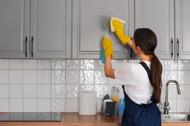 KLEAN WELL team member carefully wiping kitchen cabinet to deliver expert, spotless results