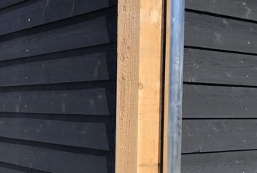 Un mur en bois suite à la fabrication d'une peinture suedoise noir