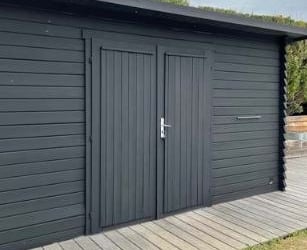 Un abri de jardin peint avec de la peinture naturelle microporeuse noir 