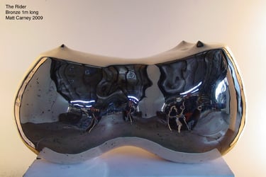 A polished bronze reflective sculpture of curved abstract form