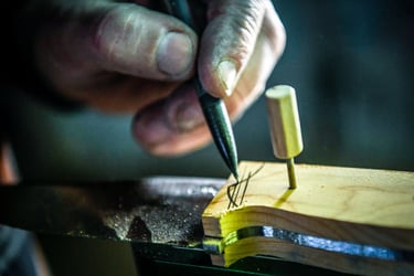 un coutelier qui dessine sur un bloc de bois